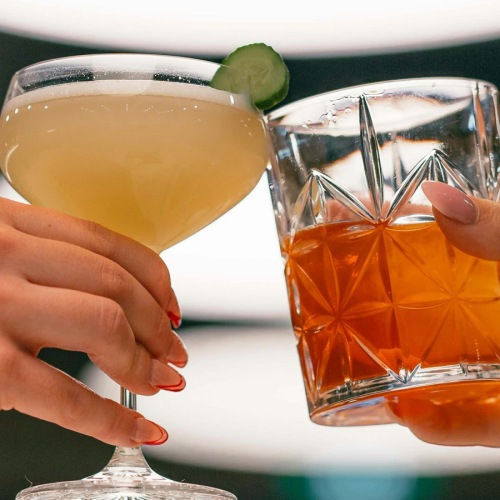 two people toasting drinks